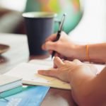 Mano de un estudiante tomando apuntes en un cuaderno